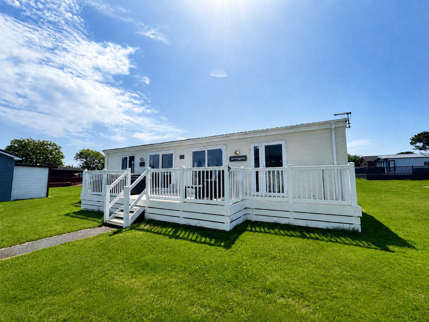Luxury lodge exterior with raised timber decking at Atlantic Bays, Padstow