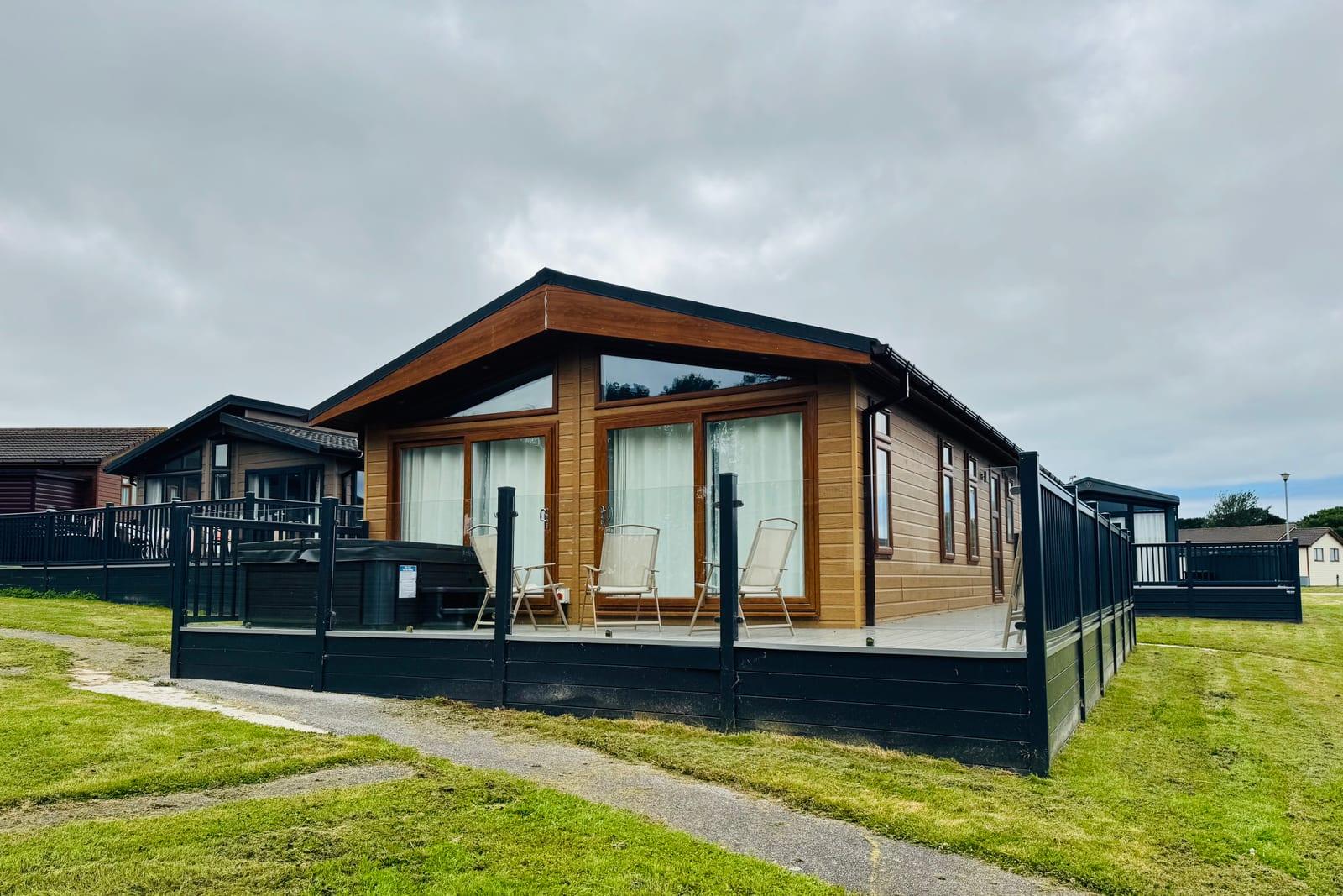 Timber-clad holiday lodge for sale with private hot tub and decking at Atlantic Bays