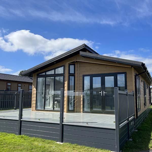 Luxury lodge exterior with raised timber decking at Atlantic Bays, Padstow