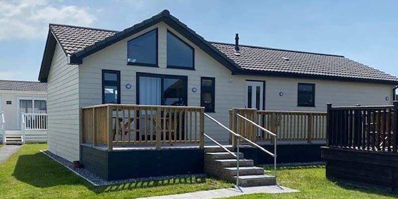 Luxury lodge exterior with raised timber decking at Atlantic Bays, Padstow