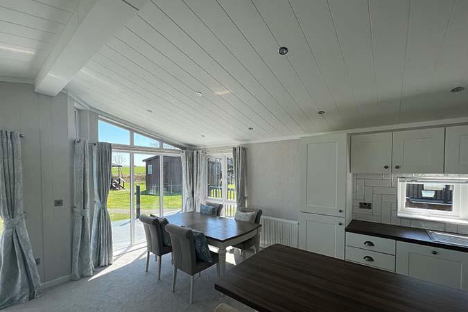 Open-plan lodge living room with sofas at Atlantic Bays Holiday Park, Padstow