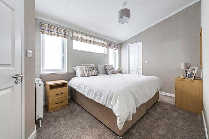 Lodge bedroom with double bed inside a luxury lodge at Atlantic Bays