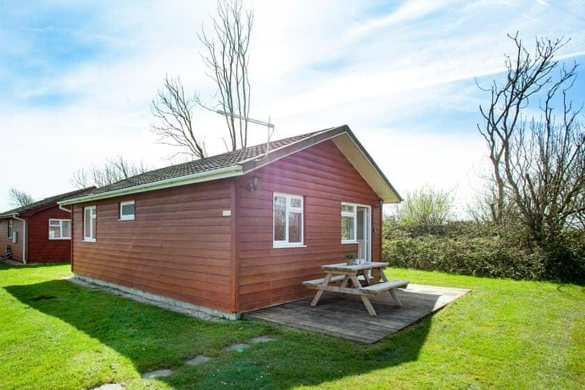 Sun Cabin exterior with decking and picnic bench at Atlantic Bays Holiday Park